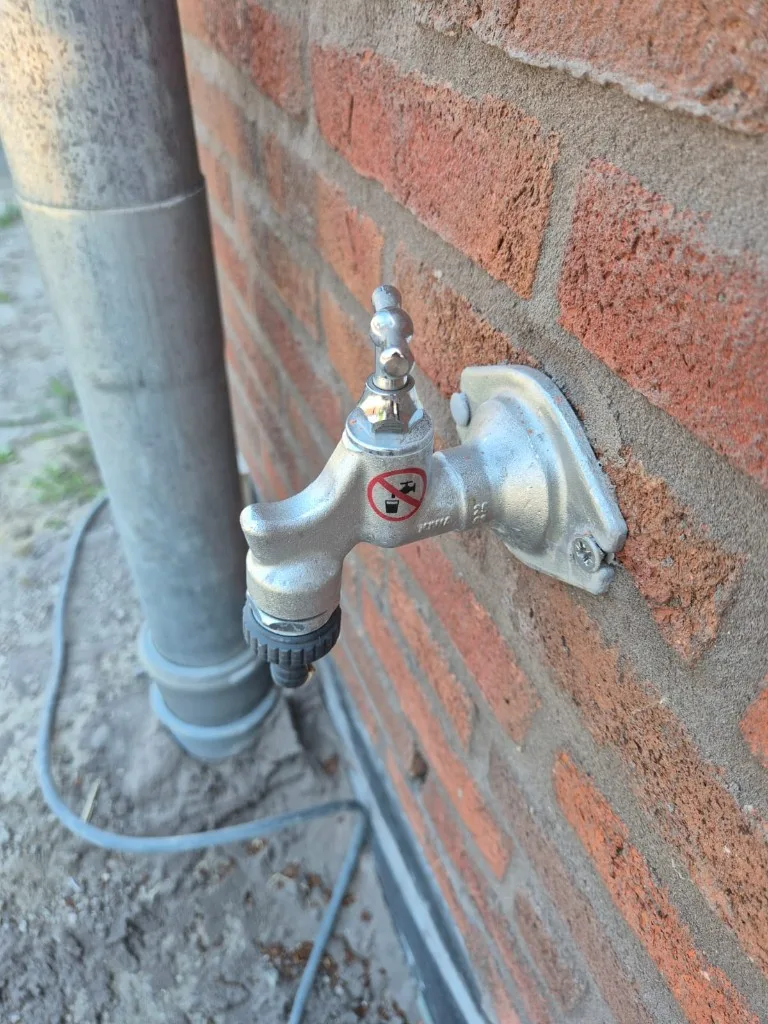 Buitenkraan met sticker niet-drinkbaar water, correct gelabeld voor de waterkeuring